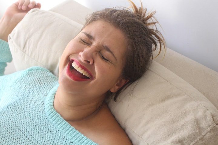 mujer feliz tumbada en el sofá tras la aplicación de bergamota