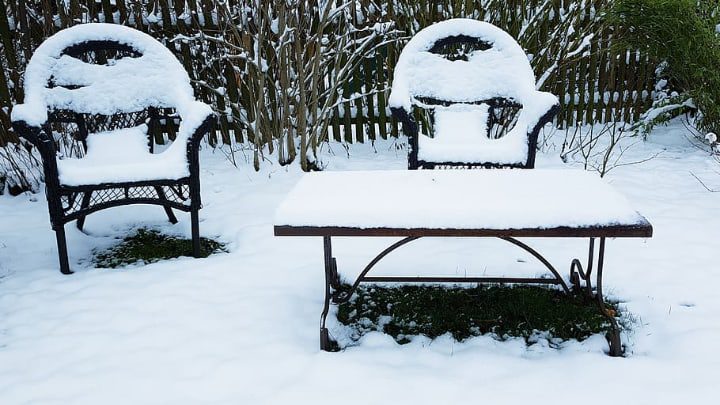 muebles metálicos de jardín cubiertos de nieve