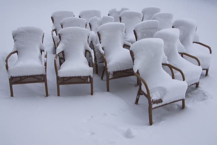 muebles de ratán cubiertos por la nieve